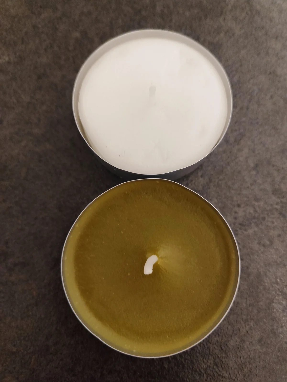 Vorher-nachher-Vergleich: weißes Wachs und Kratom-Farbton Direkter Vergleich einer weißen und einer olivgrünen Kerze mit Kratom
