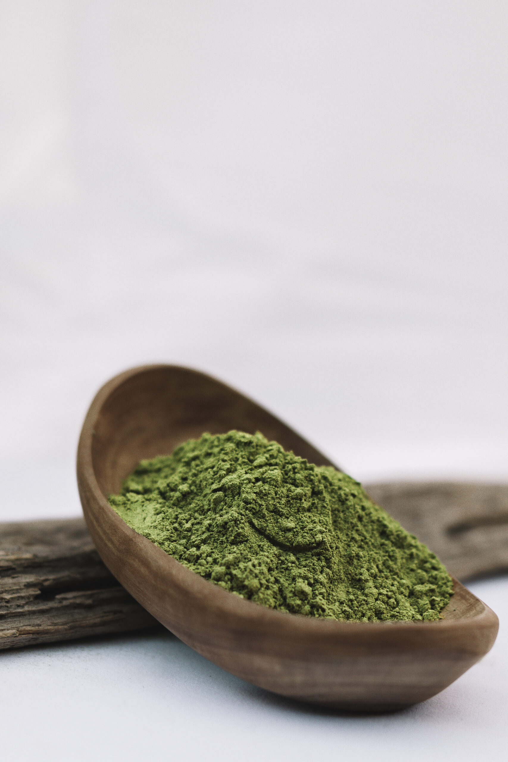Grünliches Kratom-Blattpulver als symbolische Darstellung der Green-Vein-Kategorie